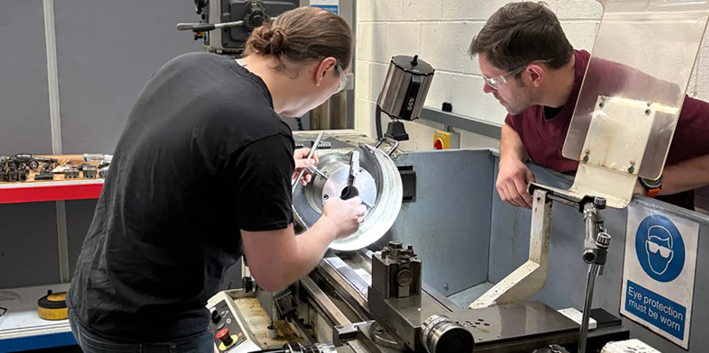 2 Fibrelite employees use a lathe by themselves.